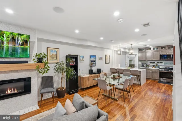 a living room with fireplace furniture and a open kitchen view