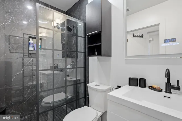 a bathroom with a toilet a sink and shower