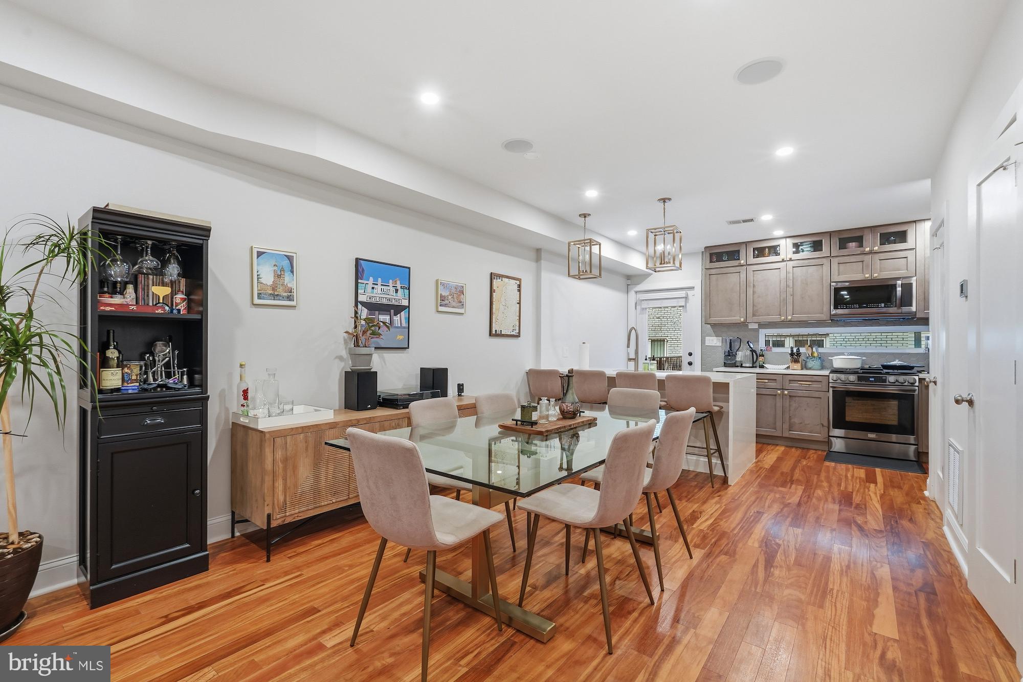 331 W Street Northeast Washington, DC 20002 - Photo 5 of 25 a kitchen with stainless steel appliances kitchen island granite countertop a refrigerator a stove a microwave oven a dining table and chairs with wooden floor