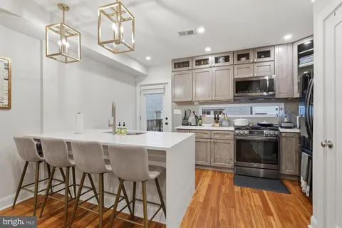 a kitchen with stainless steel appliances a stove center island and cabinets