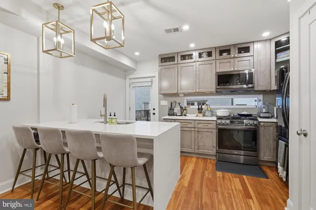 a kitchen with stainless steel appliances a stove center island and cabinets