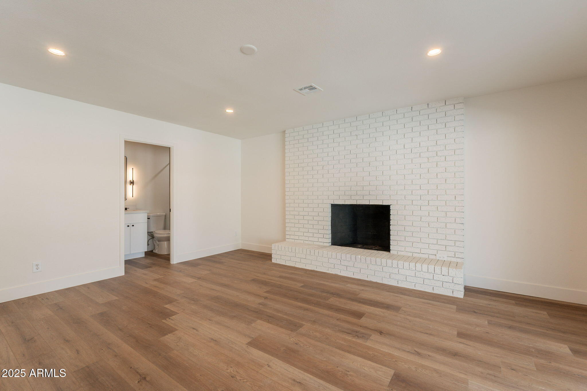 1530 East Alameda Drive Tempe, AZ 85282 - Photo 17 of 54 a view of an empty room with wooden floor and a fireplace