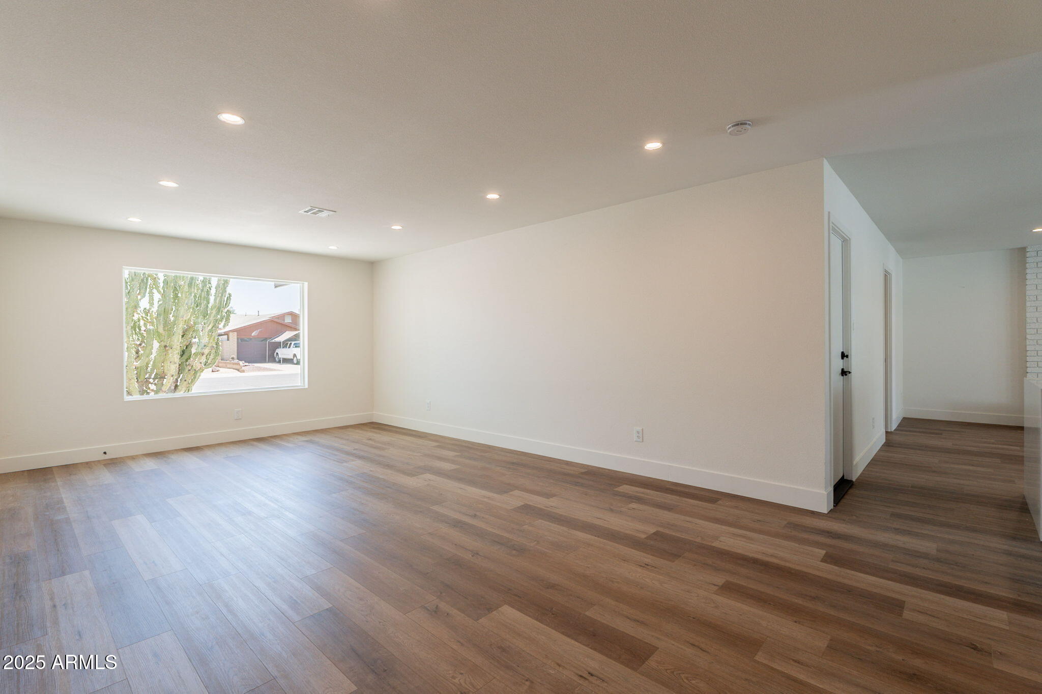 1530 East Alameda Drive Tempe, AZ 85282 - Photo 7 of 54 a view of an empty room with wooden floor and a window