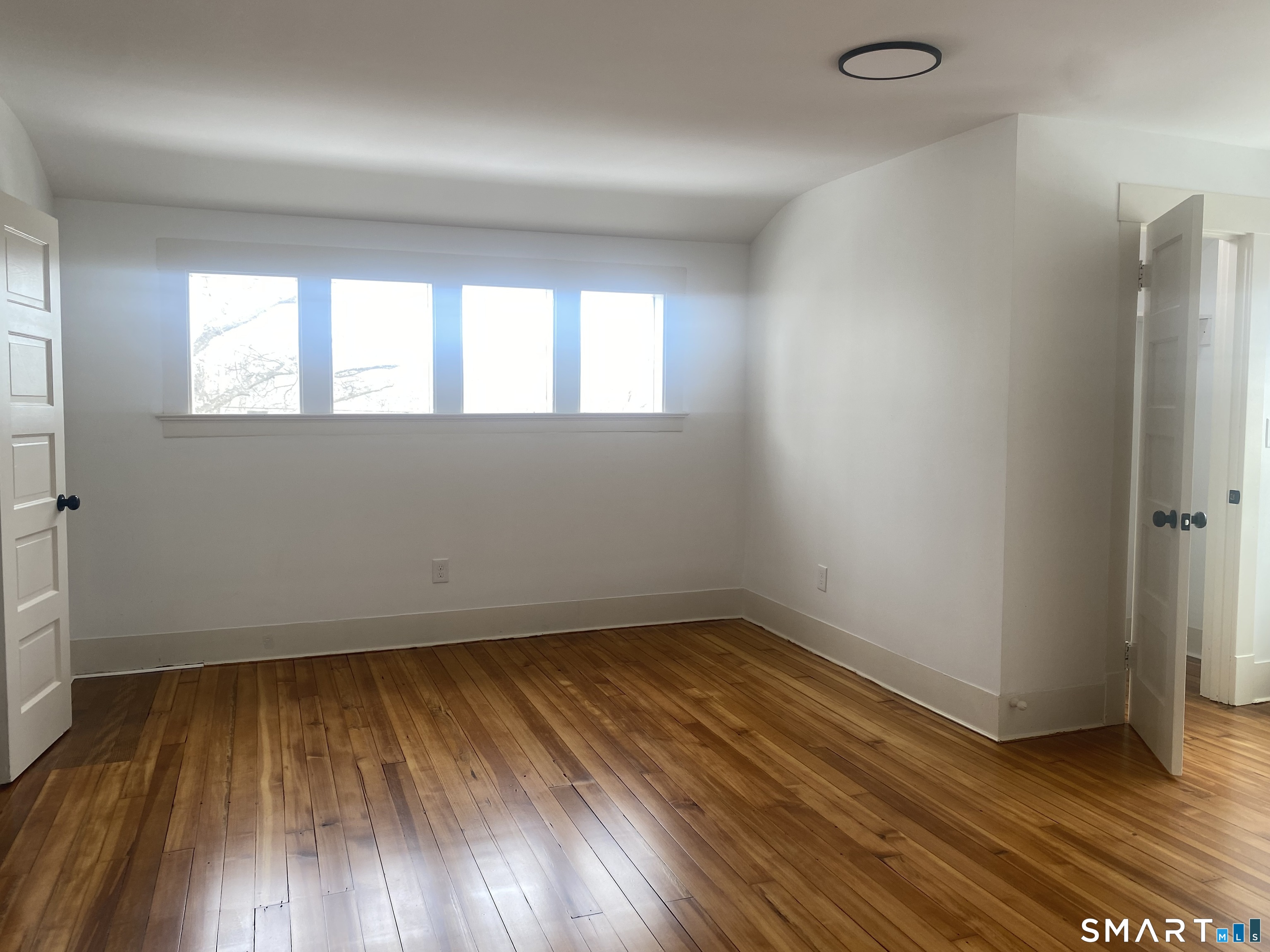 86 Foote Street Hamden, CT 06517 - Photo 8 of 14 an empty room with wooden floor and windows
