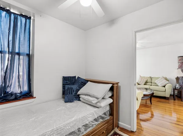 a bedroom with a bed and wooden floor
