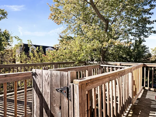 a view of balcony with wooden fence and trees