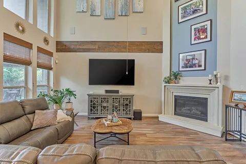 a living room with furniture a flat screen tv and a fireplace