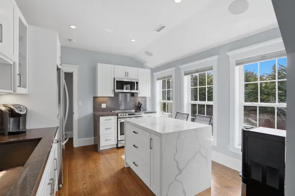 a kitchen with white cabinets and appliances