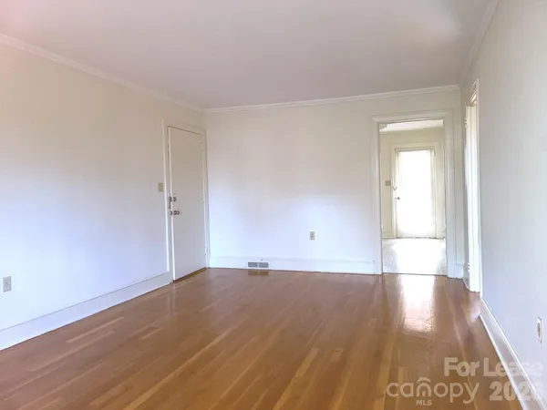 a view of a room with wooden floor and white walls