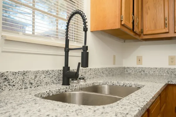 a kitchen with stainless steel appliances granite countertop a sink a stove and a microwave