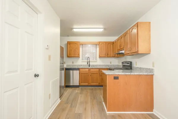 a kitchen with stainless steel appliances granite countertop a sink a stove and cabinets