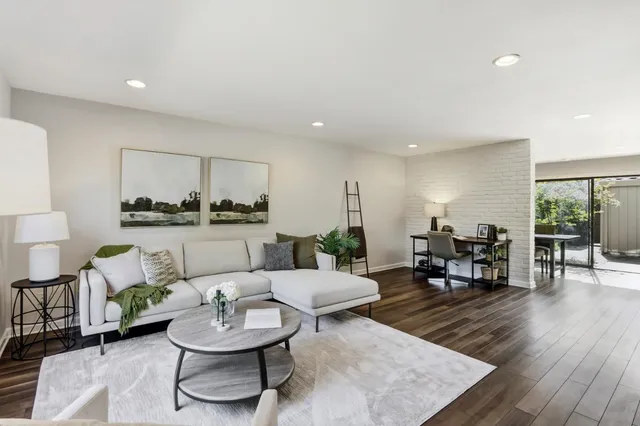 a living room with furniture and a wooden floor