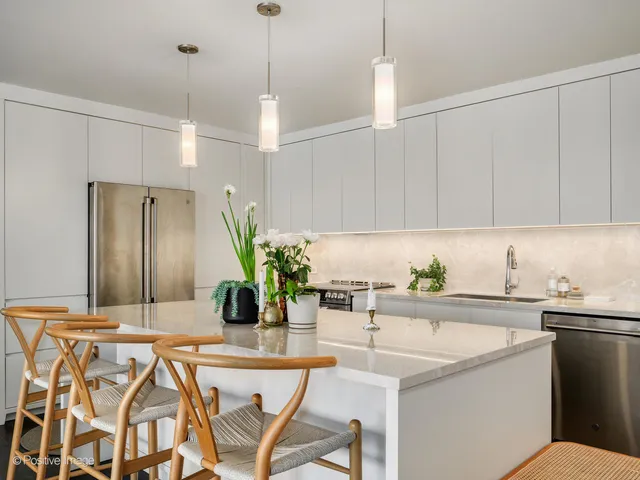 a kitchen with a sink a counter and chairs