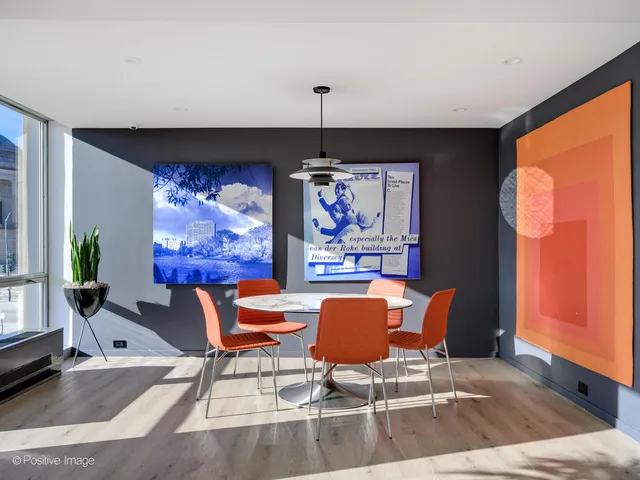 a dining room with furniture a floor to ceiling window and wooden floor