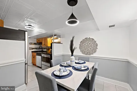a kitchen with stainless steel appliances granite countertop a dining table and chairs