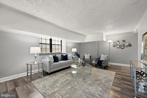 a living room with furniture a rug and a table