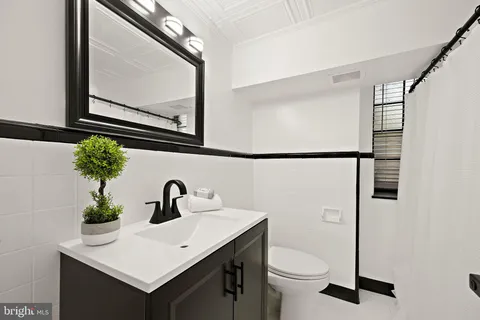 a bathroom with a toilet sink and mirror