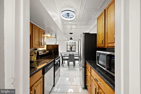 a kitchen with stainless steel appliances granite countertop a refrigerator and a stove top oven