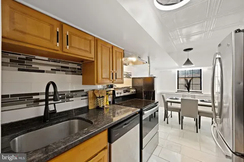 a kitchen with granite countertop a sink chairs and cabinets