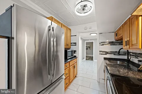 a kitchen with stainless steel appliances granite countertop a refrigerator and a stove top oven