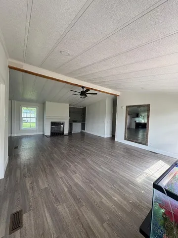 a view of empty room with a fireplace and wooden floor