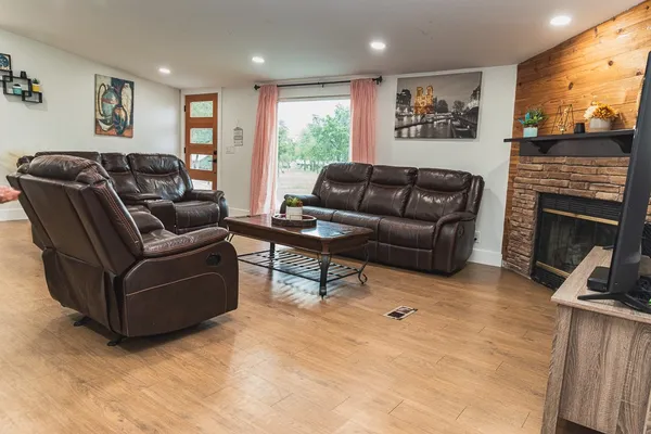 a living room with furniture a flat screen tv and a fireplace