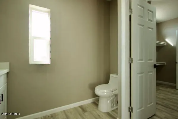 a bathroom with a granite countertop sink a toilet and a mirror