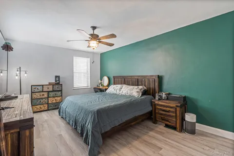 a bed sitting in a bedroom next to a window with a chandelier