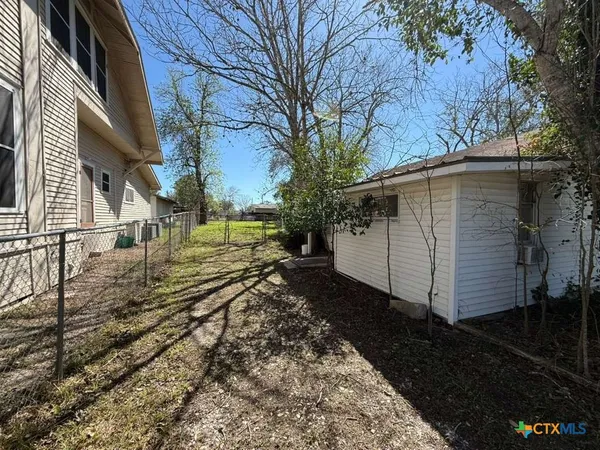 a view of a yard with wooden fence