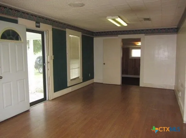 a view of a hallway with wooden floor