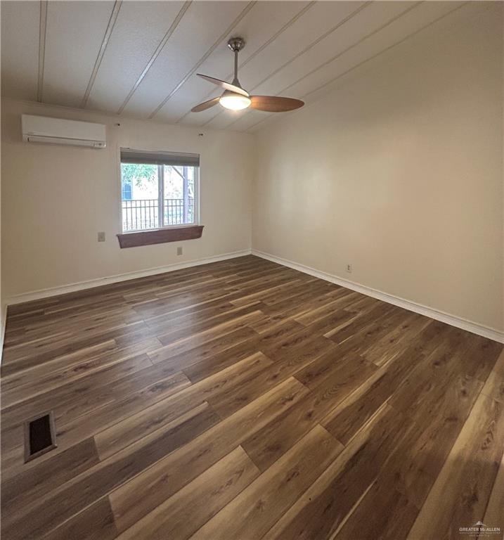 1205 Maple Street Harlingen, TX 78552 - Photo 12 of 23 an empty room with wooden floor chandelier fan and windows