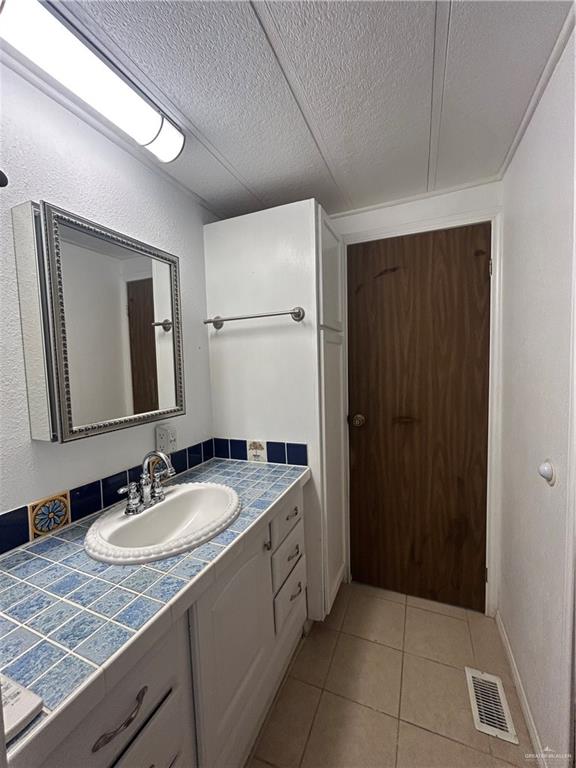 1205 Maple Street Harlingen, TX 78552 - Photo 13 of 23 a bathroom with a granite countertop sink and a mirror