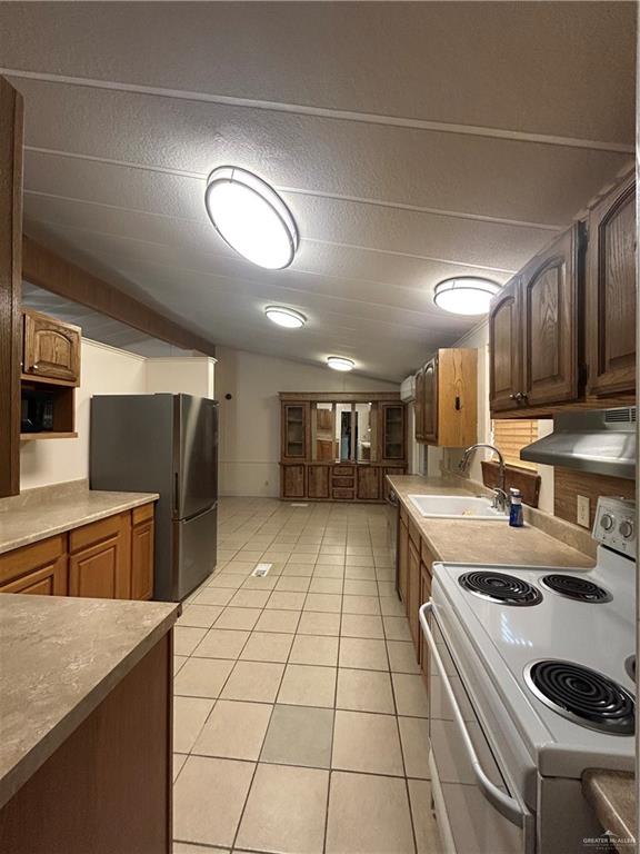 1205 Maple Street Harlingen, TX 78552 - Photo 10 of 23 a kitchen with stainless steel appliances granite countertop a sink a stove and a refrigerator