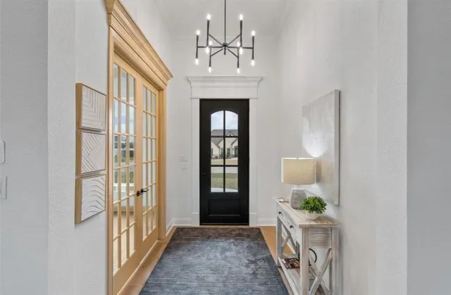 a view of an entryway door with a chandelier