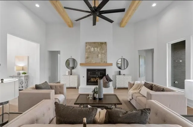 a living room with furniture a fireplace and a ceiling fan