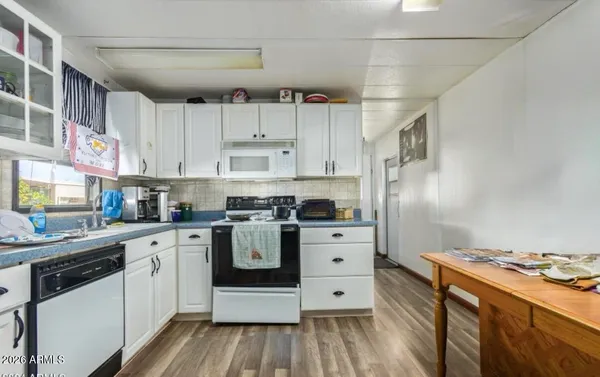 a kitchen with stainless steel appliances a stove a sink and white cabinets