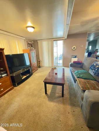 a living room with furniture a flat screen tv and a window
