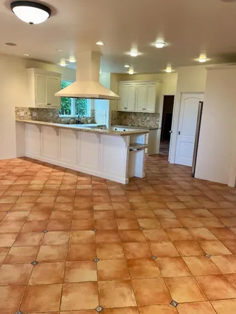 a view of kitchen with granite countertop cabinets and flat screen tv