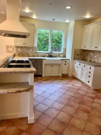 a kitchen with stainless steel appliances granite countertop a stove a sink and a microwave