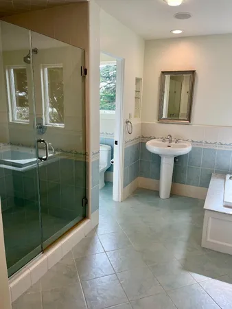 a bathroom with a bathtub sink and mirror