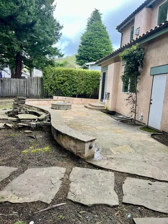 a front view of a house with a yard and trees