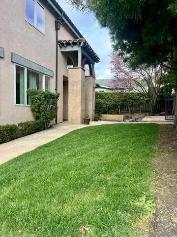 a view of a house with a big yard and large trees