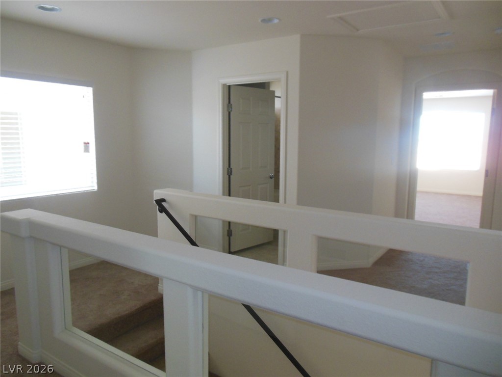 6390 Jackson Spring Road Las Vegas, NV 89118 - Photo 16 of 27 Upper level landing with a well-lit window and inviting pathways to adjacent rooms.