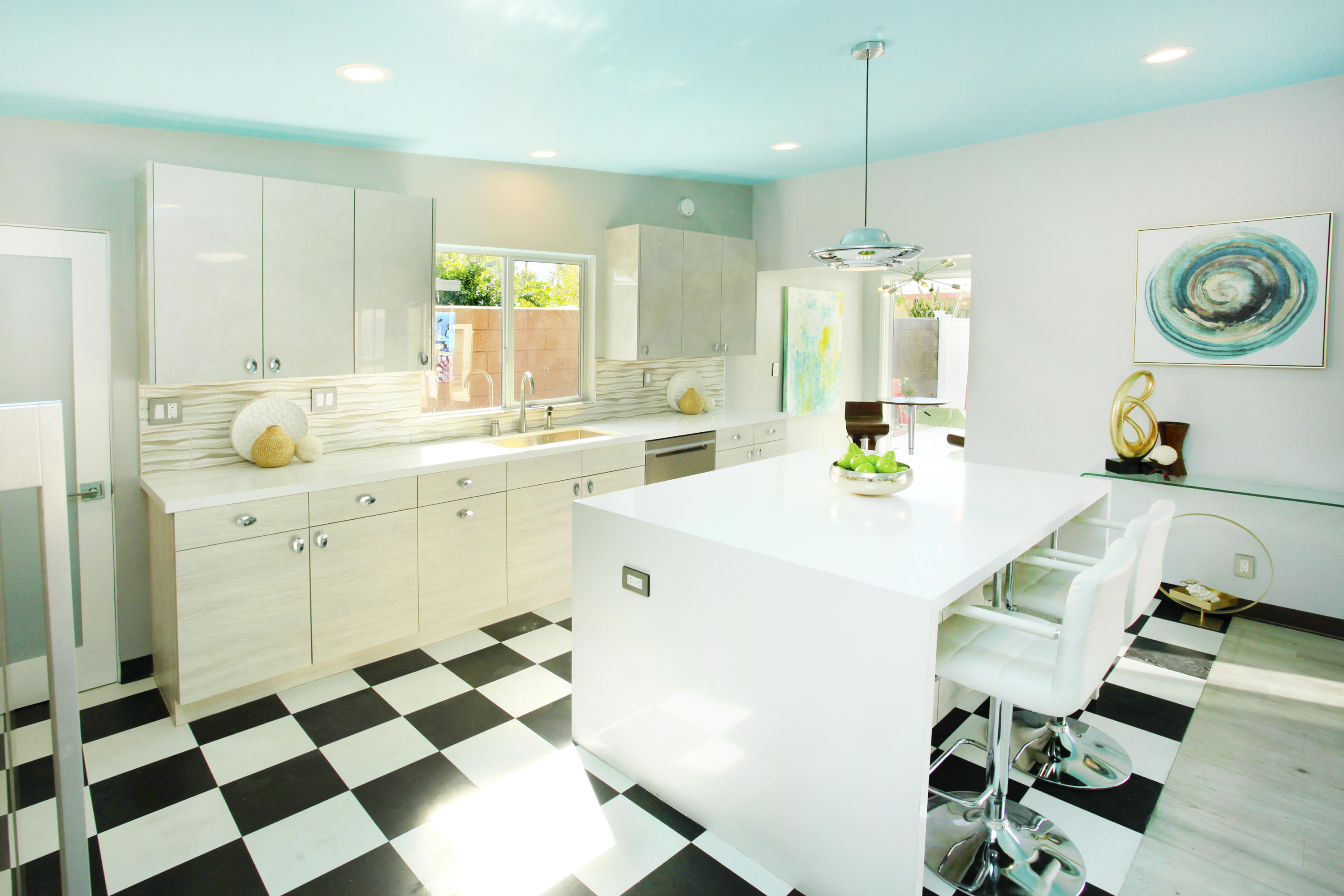 71991 Vista Del Rio Rancho Mirage, CA 92270 - Photo 13 of 34 a kitchen with a sink a stove a dining table and chairs