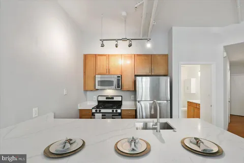 a living room with furniture wooden floor and a kitchen view