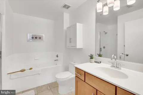 a living room with furniture kitchen view and a potted plant