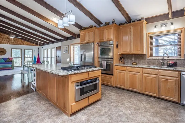 a kitchen with stainless steel appliances granite countertop a stove a sink and a refrigerator