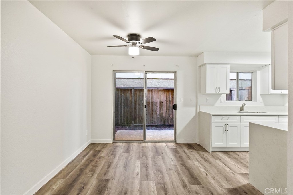 221 10th Street Huntington Beach, CA 92648 - Photo 13 of 20 a view of a kitchen from the hallway with a sink and chandelier fan