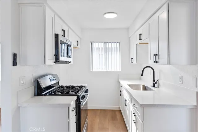 a kitchen with stainless steel appliances granite countertop a sink stove and a refrigerator