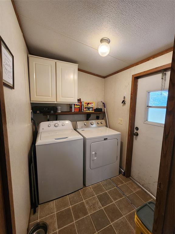 7120 Golden Meadows Road Greenwood, LA 71033 - Photo 6 of 14 Washroom featuring crown molding, dark tile patterned floors, washing machine and dryer, a textured ceiling, and cabinet space